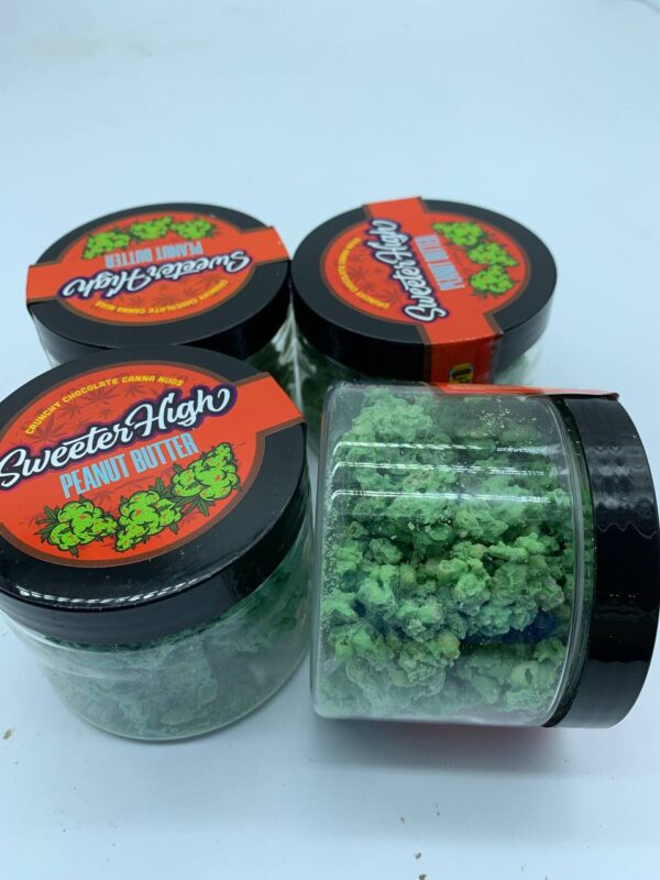 A jar of Sweeter High weed strain with vibrant buds, showcasing a balanced, sweet, and earthy aroma.