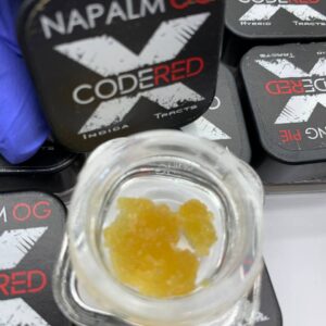 A 1g jar of Code Red Diamonds concentrate, showcasing its crystalline structure and rich THC content.