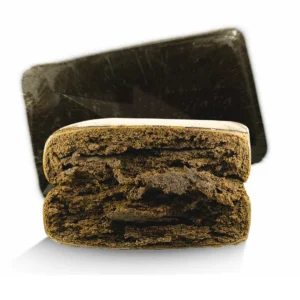 Dark brown hashish chunk labeled BROWNY, resting on parchment paper with visible texture and rich, earthy coloration.
